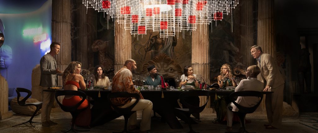 GLASS ONION: A KNIVES OUT MYSTERY (2022) (L-R) Edward Norton as Miles, Madelyn Cline as Whiskey, Kathryn Hahn as Claire, Dave Bautista as Duke, Leslie Odom Jr. as Lionel, Jessica Henwick as Peg, Kate Hudson as Birdie, Janelle Monae as Andi, and Daniel Craig as Detective Benoit Blanc.Cr: Courtesy NETFLIX