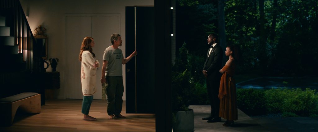 LEAVE THE WORLD BEHIND (2023) Julia Roberts as Amanda, Ethan Hawke as Clay inside the home, with Mahershala Ali as G.H. and Myha’la as Ruth just outside the front door. CR: Courtesy NETFLIX