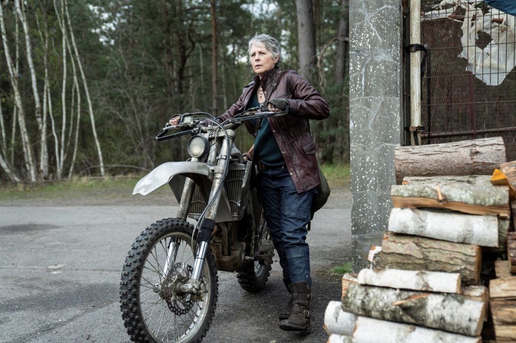 Carol (Melissa McBride) stands with a motorbike in The Walking Dead: Daryl Dixon - The Book of Carol